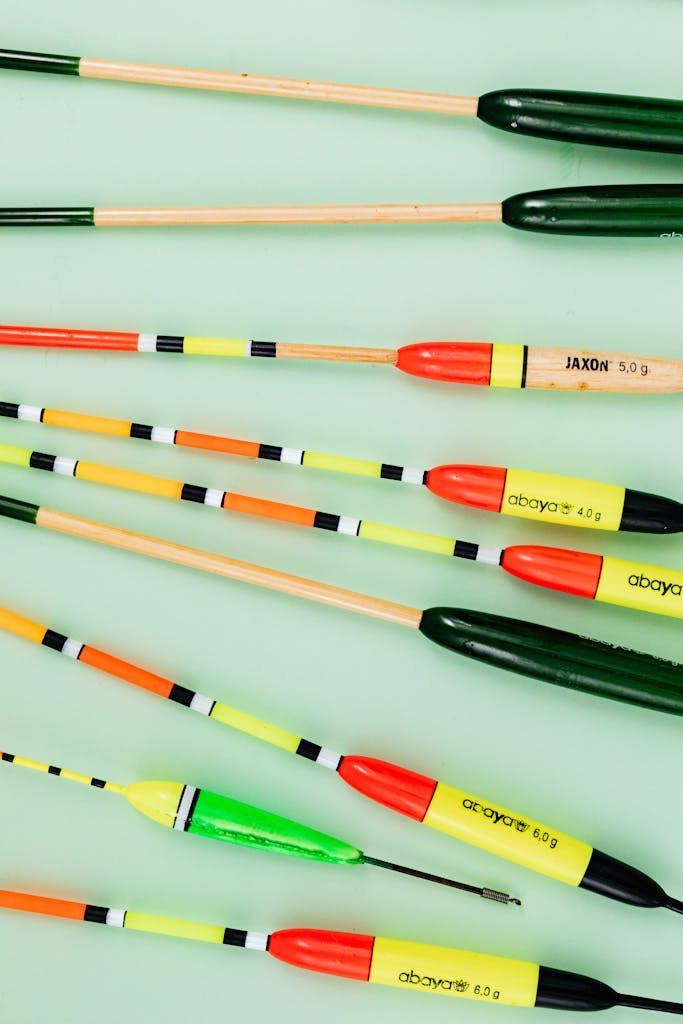 fisherneeds Vibrant fishing floats arranged on a green surface, showcasing various colors and patterns.